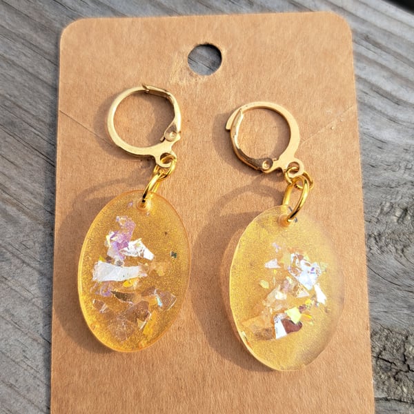 Oval resin earrings filled with gold and multicoloured glitter flakes
