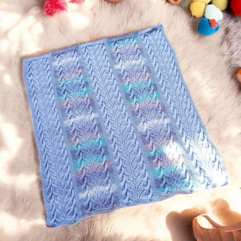 Baby blanket hand knitted in blue mixture stripes and cables