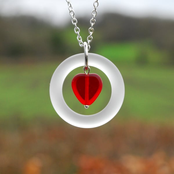 White glass ring with red heart