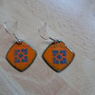 Square earrings with blue design on orange 
