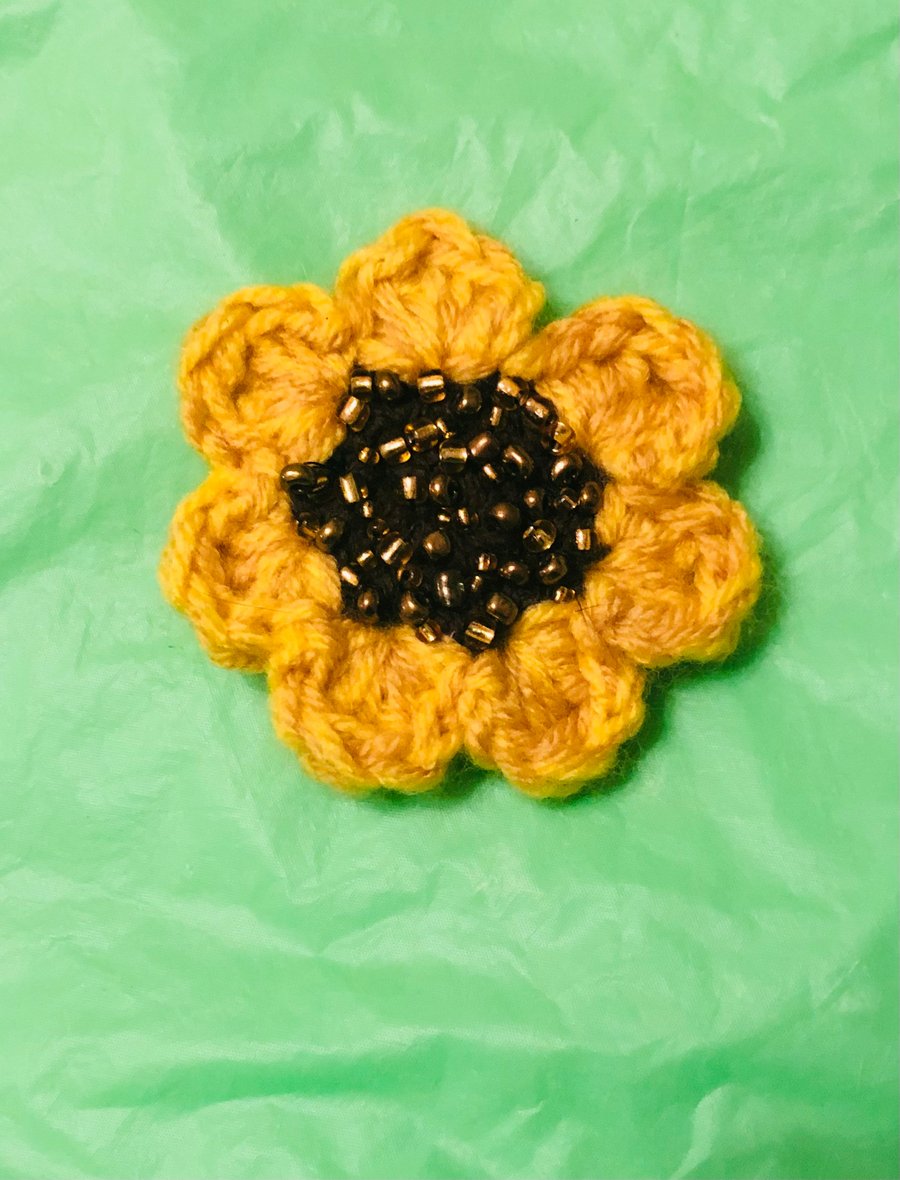 Crochet sunflower brooch embellished with seed beads