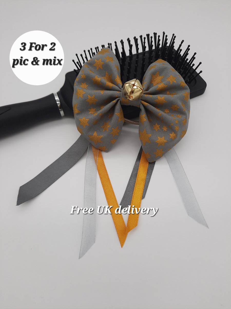 Hair bow grey gold star with ribbons and bell.  