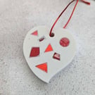 A handmade jesmonite heart filled with bright red hand dyed aluminium pieces