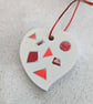 A handmade jesmonite heart filled with bright red hand dyed aluminium pieces