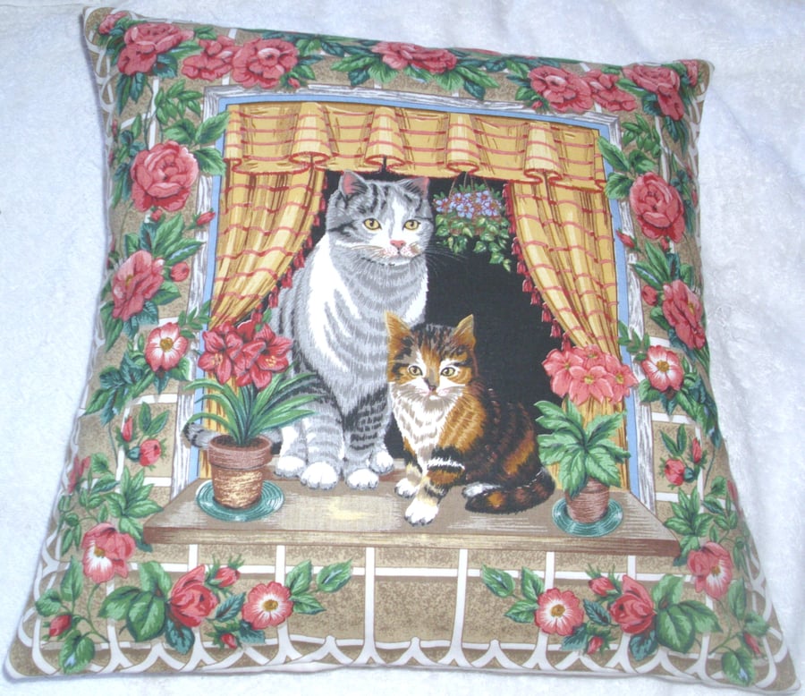 Lovely Grey Tabby cat and pretty tortoiseshell kitten sitting in window cushion