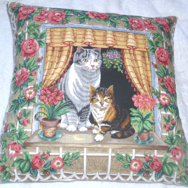 Lovely Grey Tabby cat and pretty tortoiseshell kitten sitting in window cushion