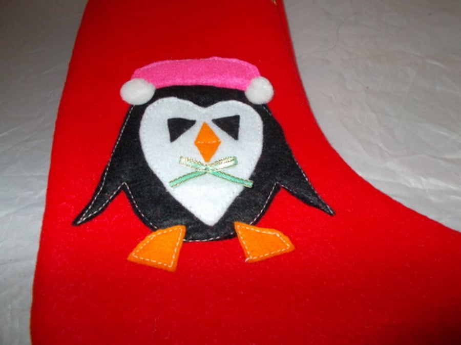 Hand made red felt Christmas stockings with appliqued penguin