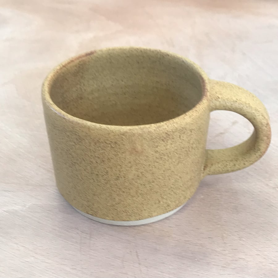  Stoneware pottery mug finished in natural sand colour glaze.