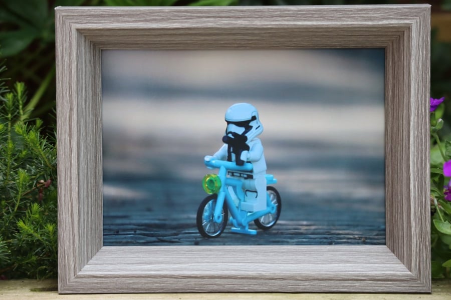 Framed photo of Lego figures. A Stormtrooper guarding the bridge on his bike.