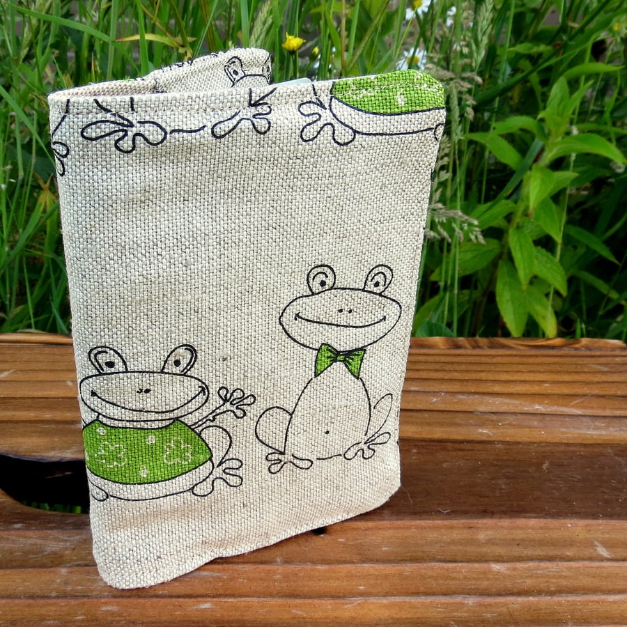 A fabric passport cover with a whimsical frog design.