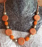 Handmade orange and gold swirl polymer clay disc necklace