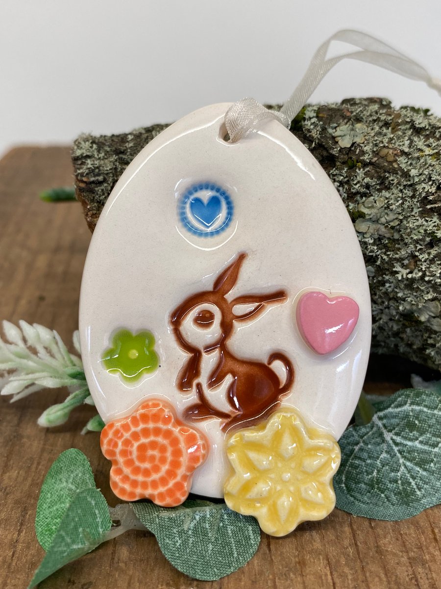 Pottery Easter Egg decoration with bunny in the flower meadow 
