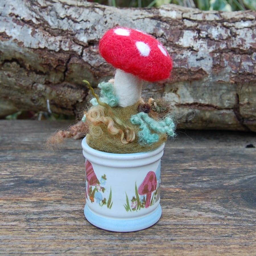 Needle felt mushroom displayed in a vintage egg cup decorated with mushrooms