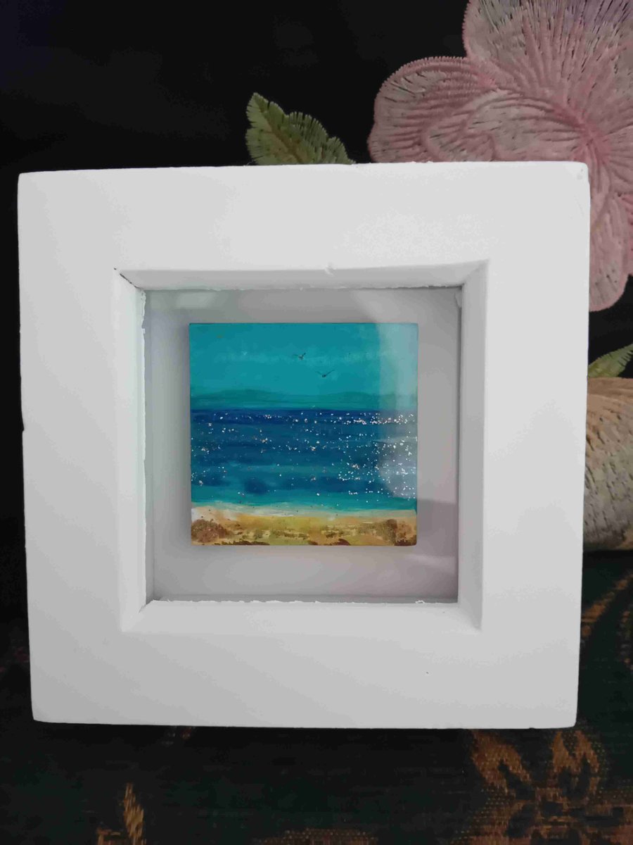  Handpainted shimmering seascape and golden sand, in white wooden box frame.