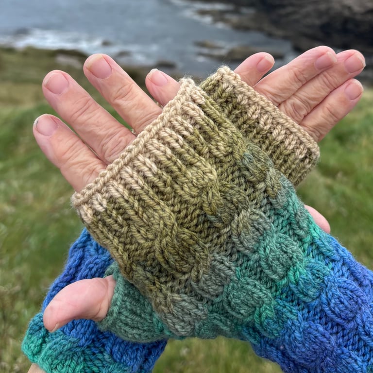 Hand knitted fingerless gloves featuring cable knit pattern.     MOUNTAIN RIVER 