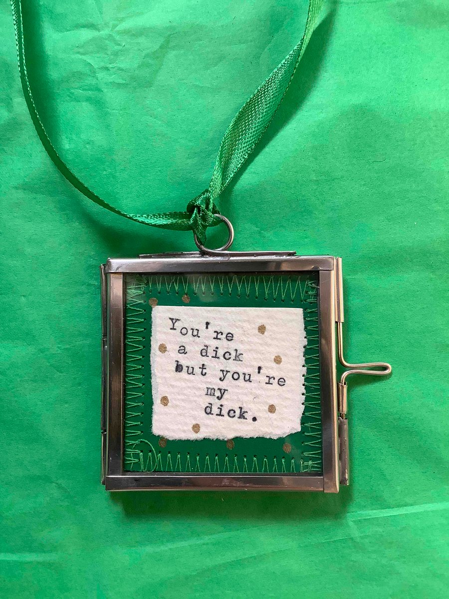 Small silver hinged frame. Wall art. Fun. You’re a dick. Insults.