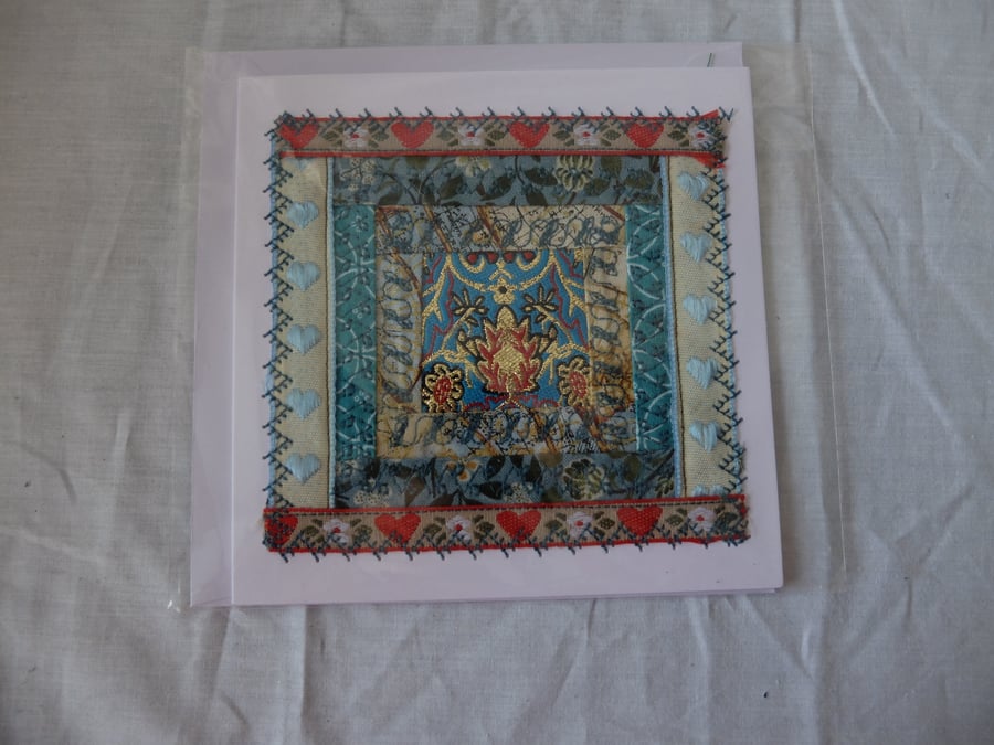 Log cabin quilt block with fragment of ribbon centre, embroidered