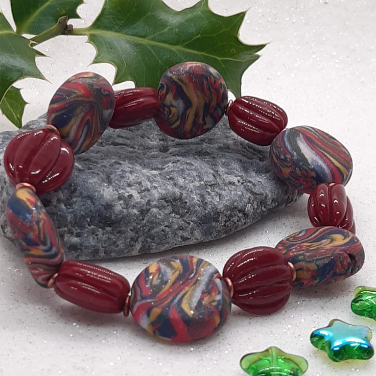 Disc shaped bracelet in red, navy and gold swirl 