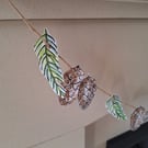 Linoprinted bunting of pinecones and pinesprigs