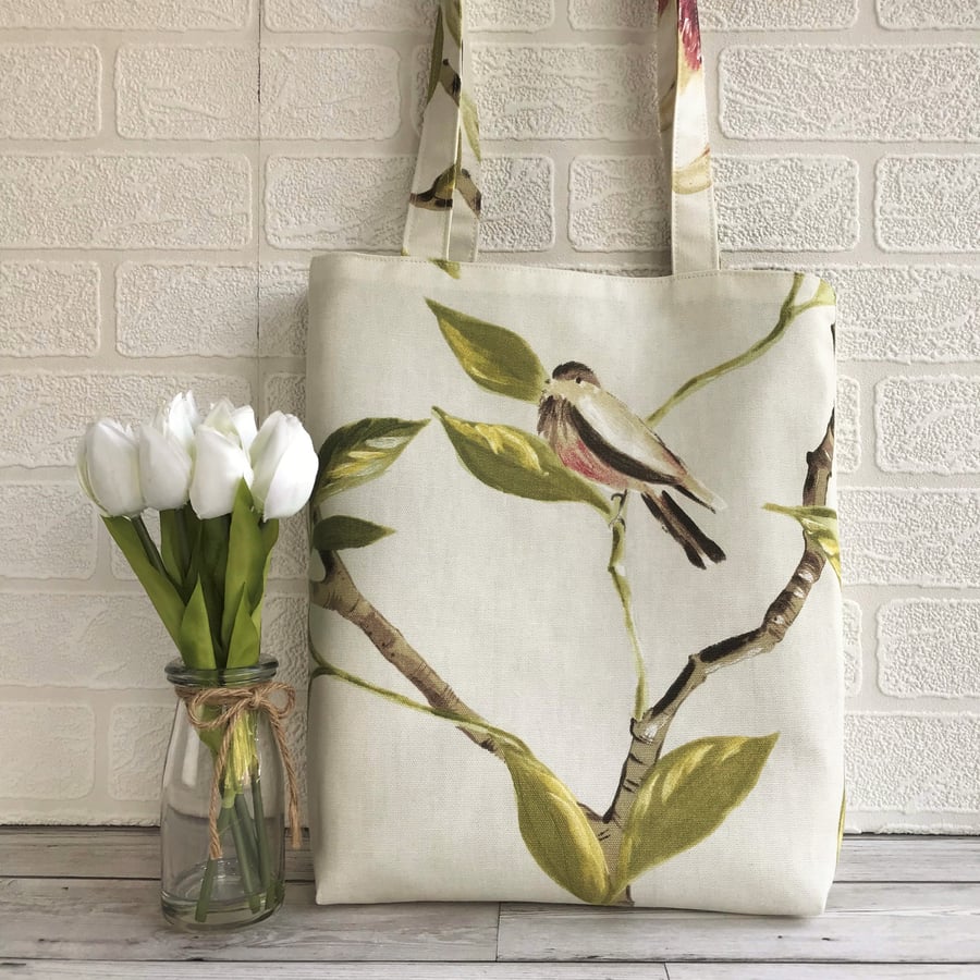 Bird tote bag with a cream, red and black bird perched on a leafy branch