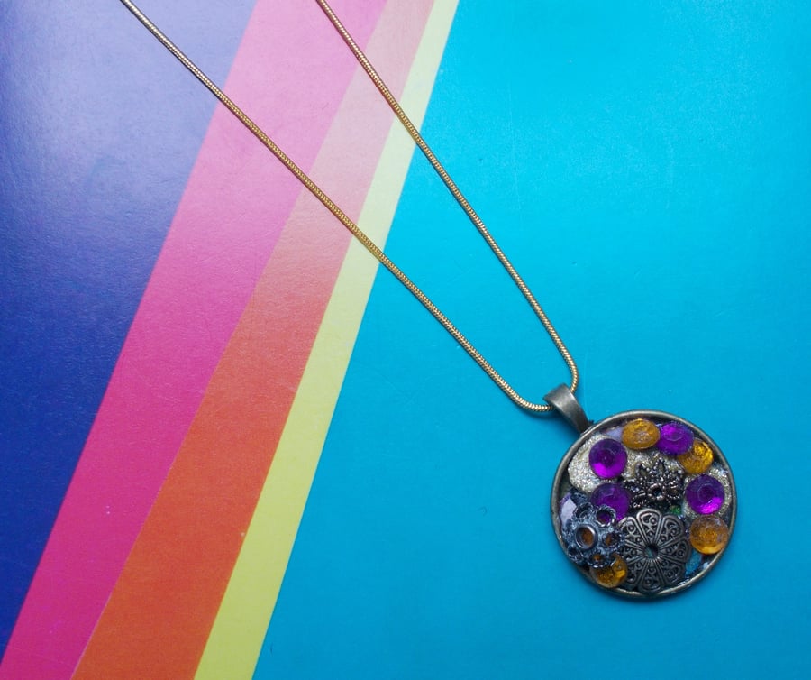 A Rich Bejewelled Pendant In Golds, Purples and Orange
