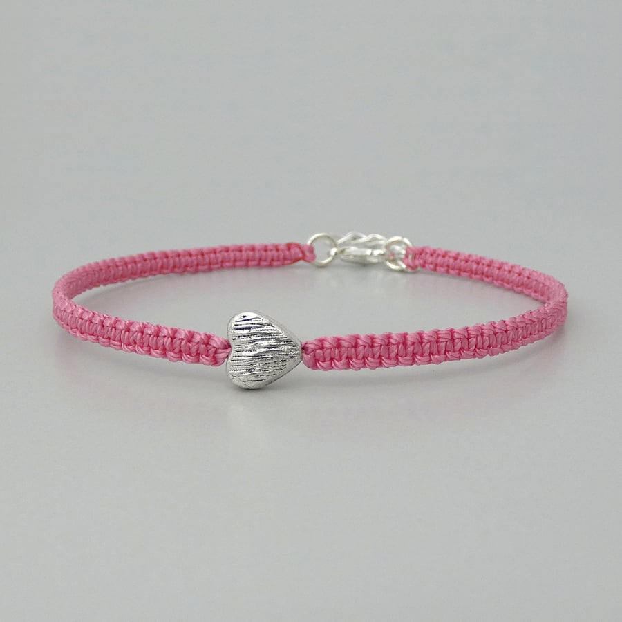 Pink 7" macramé bracelet with silver plated heart charm and 1” extender chain.