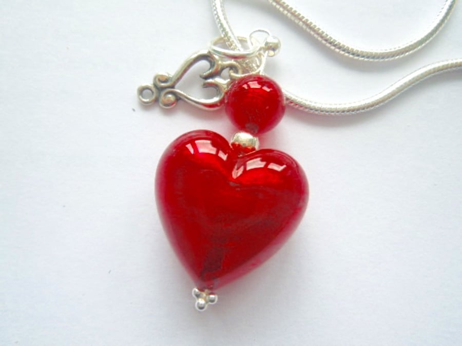 Red Murano glass heart pendant with sterling silver charm and chain.