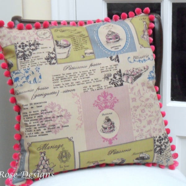 Cushion cover in a 'Patisserie' print with a pink bobble trim. 
