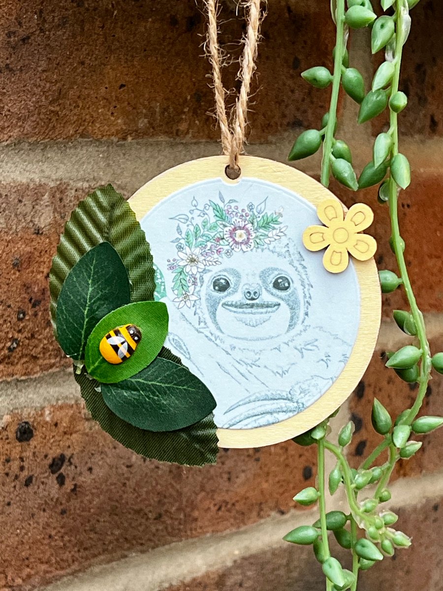 ‘Wooden hanging decoration’ - Artists Illustration of a ‘Smiling Sloth with bee’