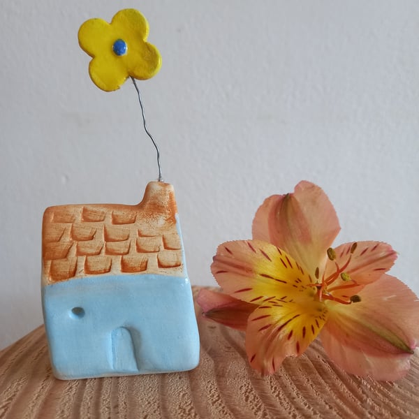 Ceramic clay cottage with flower