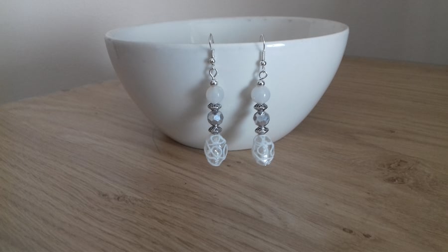 CRYSTAL, WHITE AND SILVER DANGLE EARRINGS.