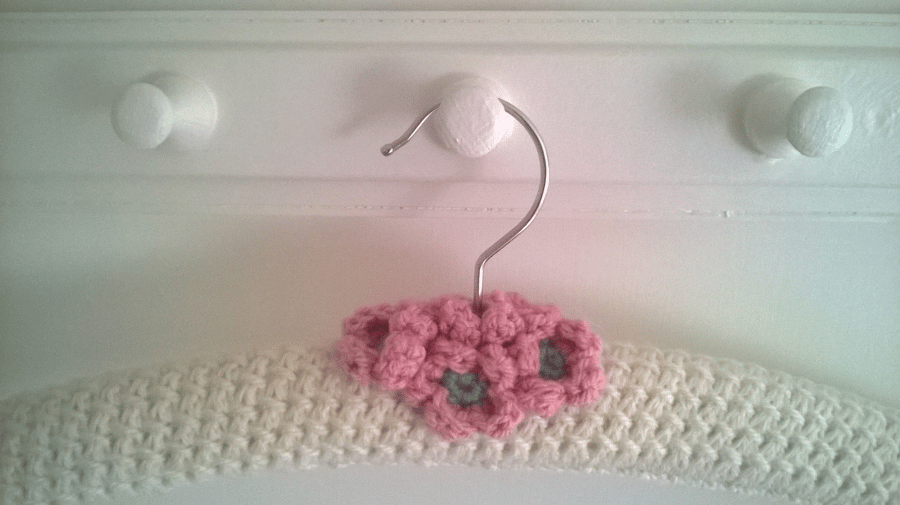 Hand knitted cream coat hanger with apple blossom flowers