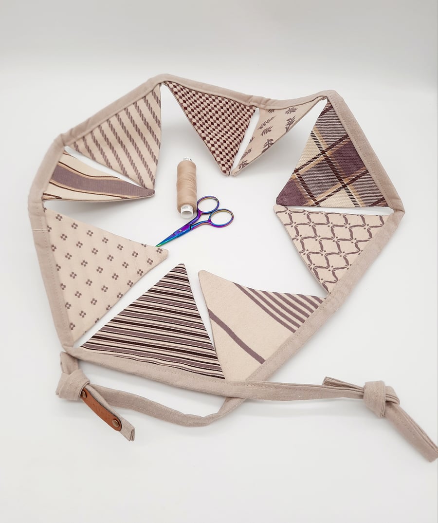 Fabric bunting in cream and purple,  9 triangles.  