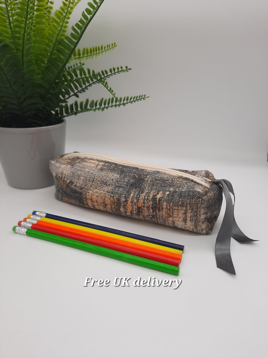 Pencil case box shaped in gold and grey. 