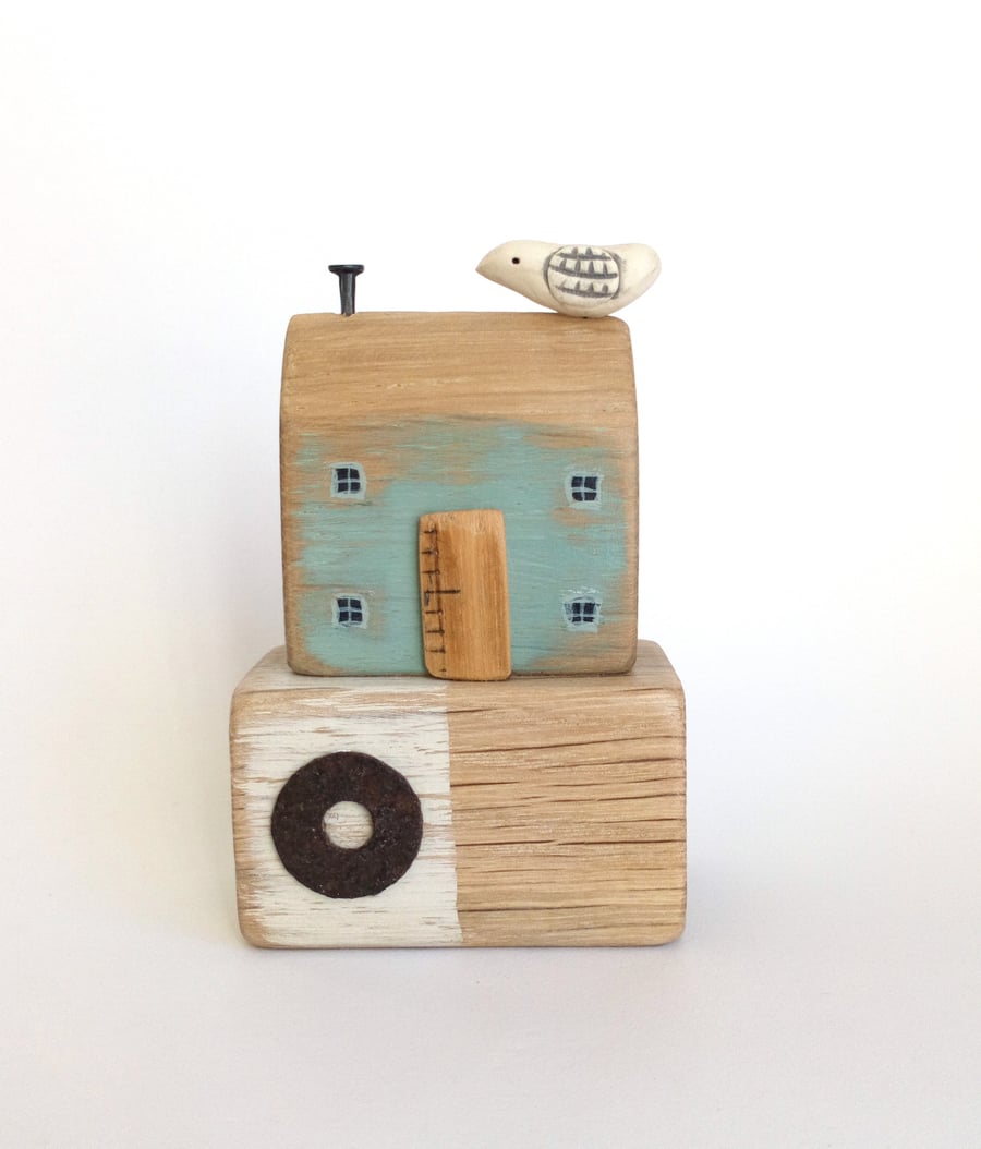 Little wooden seaside house with clay bird