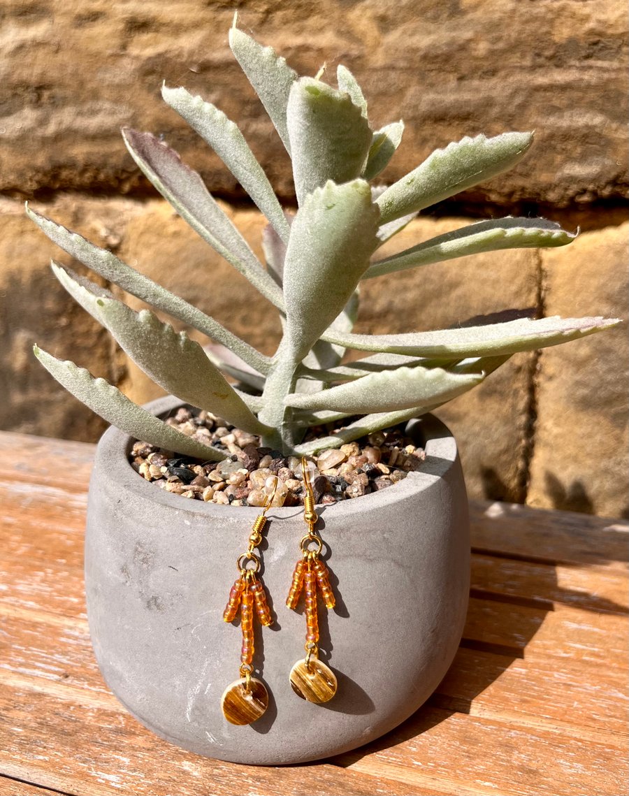 Pearlised shell and orange beaded dangle earrings