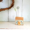 Little wooden house with a clay flower and leaf