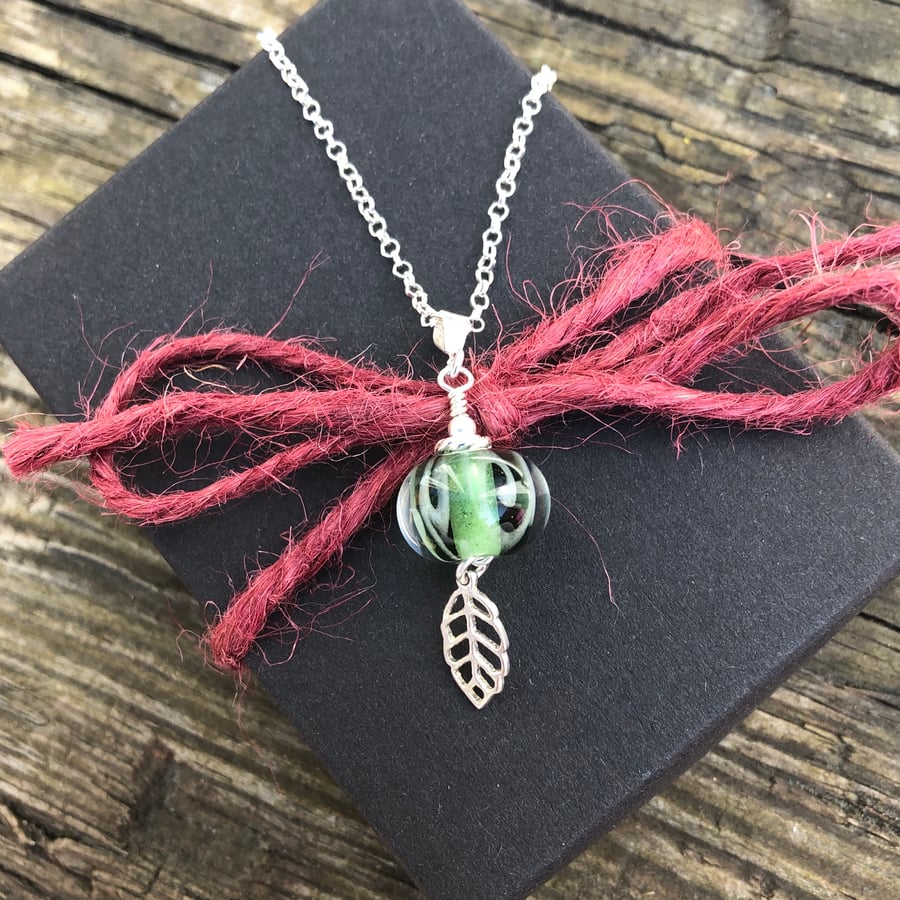 Green lampwork glass necklace with leaf charm. Sterling silver.
