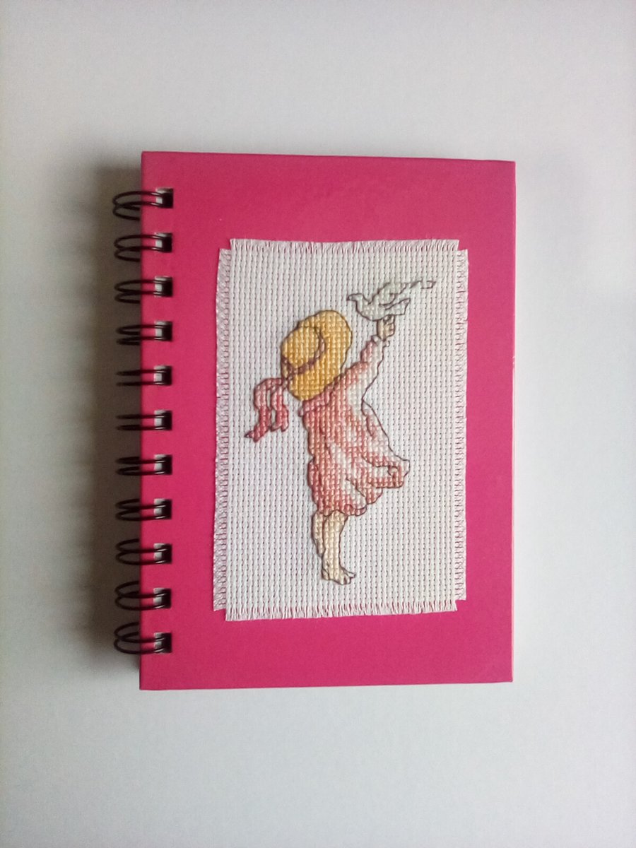 Hand stitched cross stitch spiral bound ruled notebook.