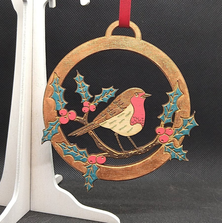 Robin in amongst holly, hand-drawn & hand painted, laser-etched, and cut out of 