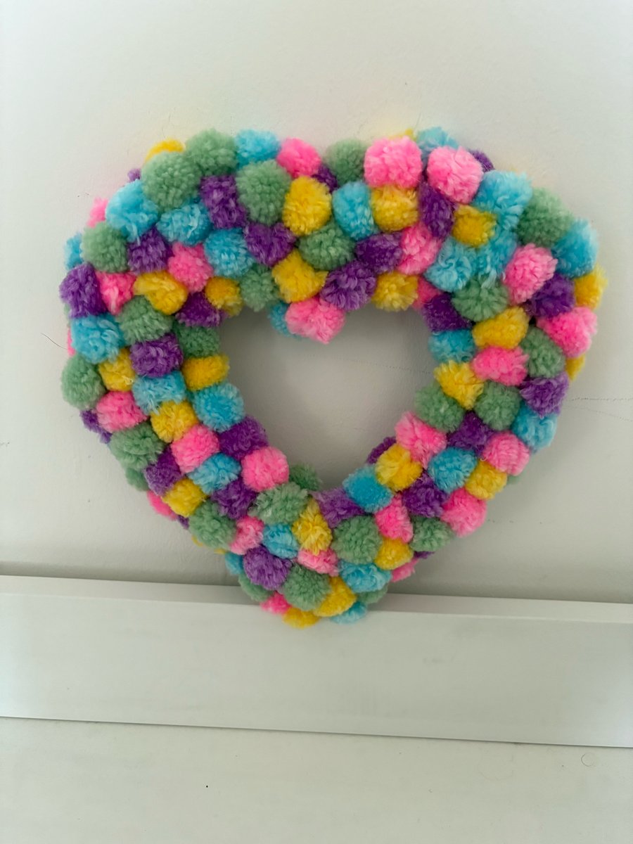 Pastels Pom Pom decorated wood heart. 