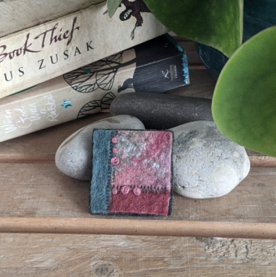 Felted patchwork brooch in shades of duck egg and terracotta.