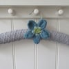 Hand knitted padded coat hanger with blue poppy flower
