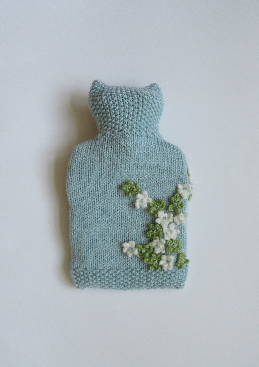 Hand knitted blue ditsy hot water bottle cover