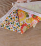Handmade mini bunting made in an orange and yellow floral theme.