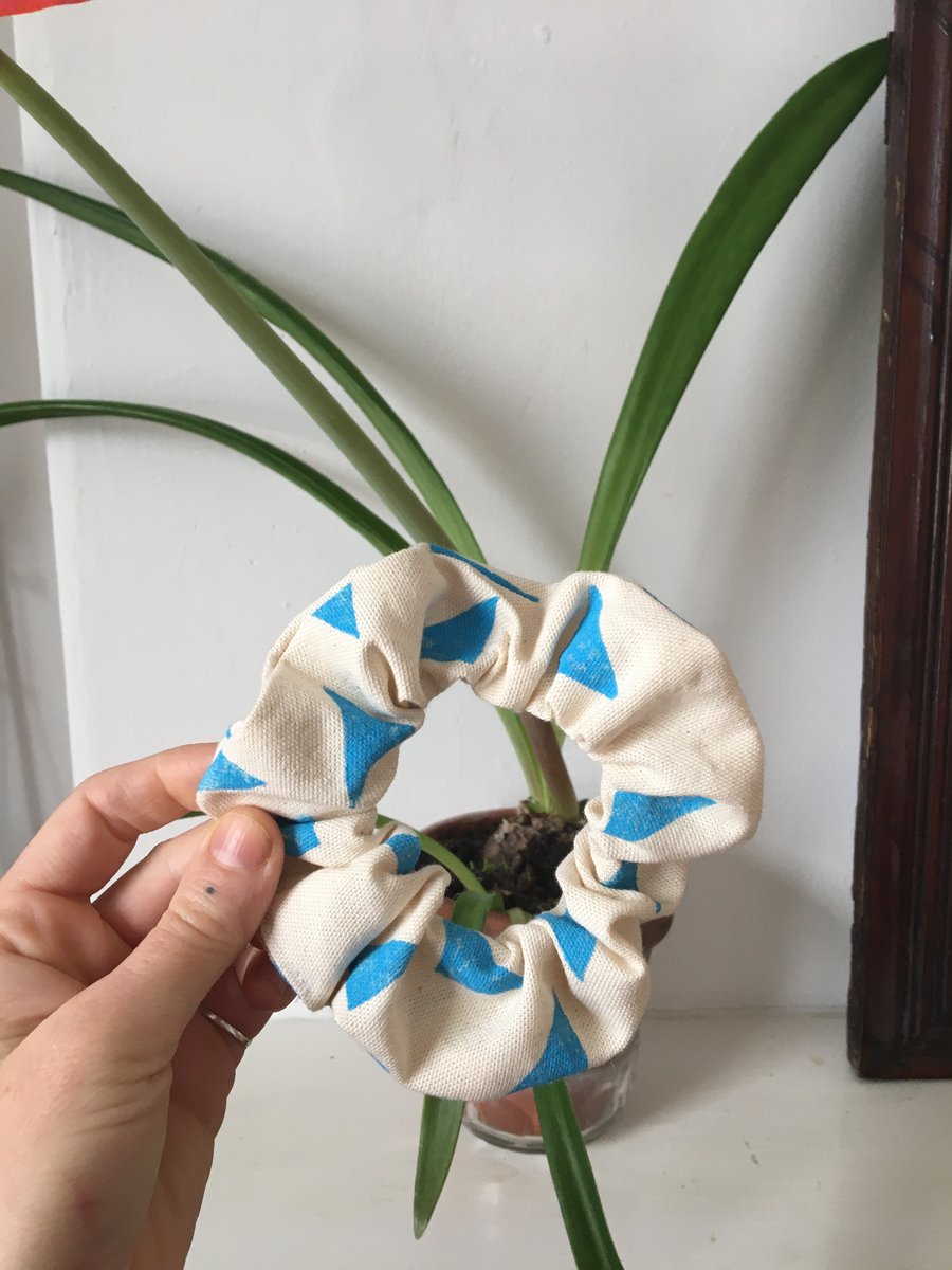Handmade organic cotton scrunchie, block printed with a blue triangle print.