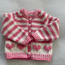 Baby’s pink and cream striped cardigan with heart motifs