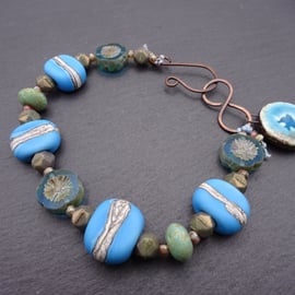 blue lampwork glass beaded bracelet, ceramic bird charm