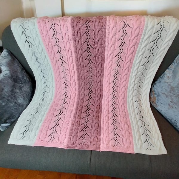 Hand-knitted baby blanket with pink and white cable lace stripes, perfect gift. 