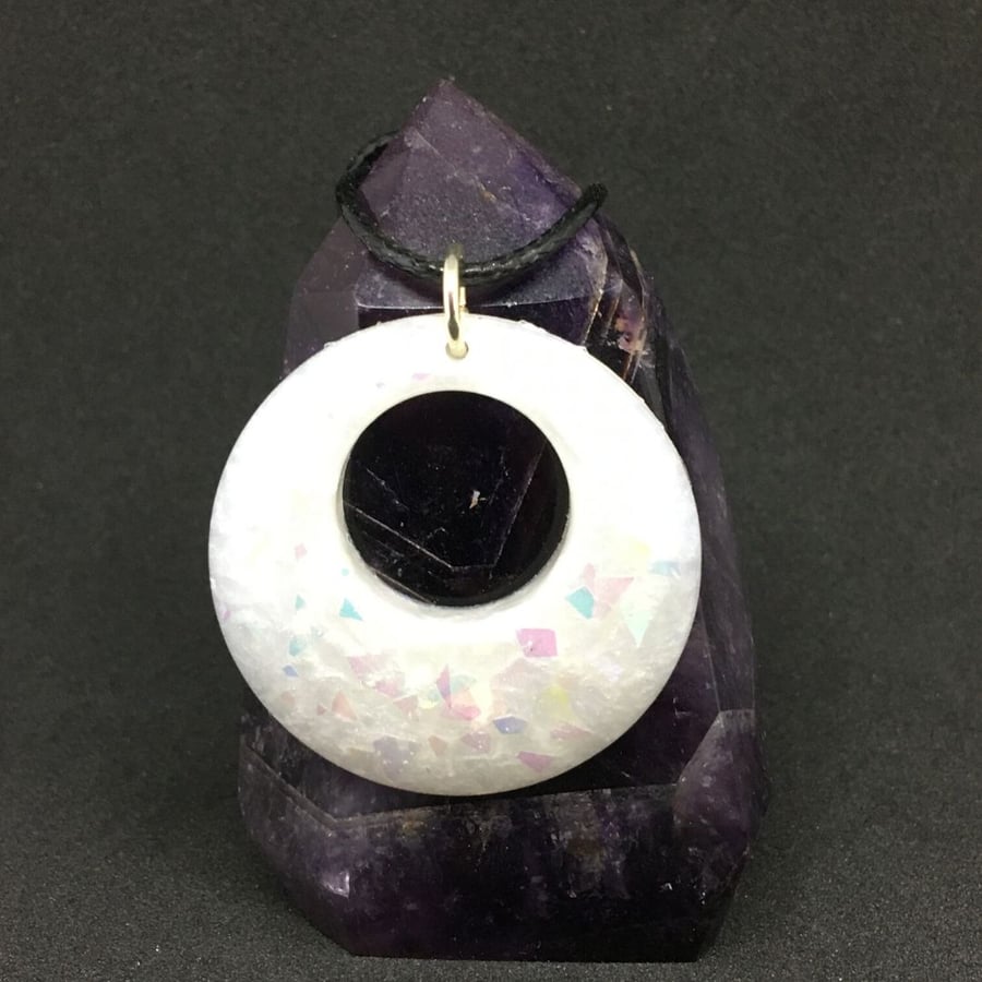 White holographic opal effect donut necklace encased in resin.